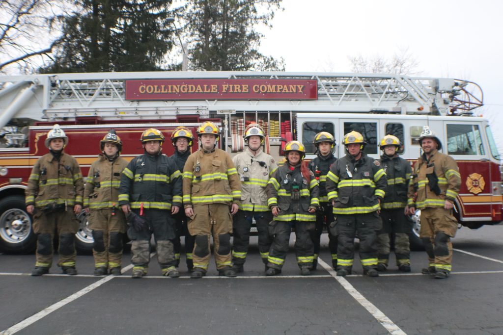 Ten firefighters in full gear stand in front of a red fire truck labeled "Collingdale Fire Company," posing for a group photo in a parking lot.