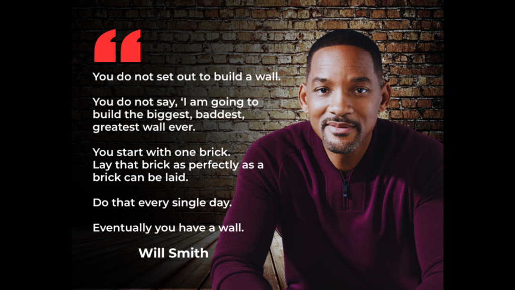 Will Smith sits against a brick wall background. Beside him is a quote about achieving goals by laying one brick at a time, which leads to building a wall through consistent daily effort.