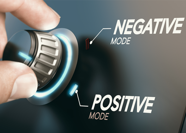 A hand turns a metallic dial on a control panel with glowing blue accents, switching between "NEGATIVE MODE" and "POSITIVE MODE" labeled in bold white text.