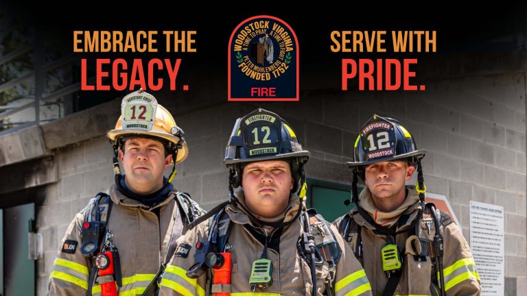 Three firefighters in full gear stand before a building. Above them, text reads "Embrace the Legacy." and "Serve with Pride." with the Woodstock Fire Department emblem in the center—showcasing our public safety video production expertise.